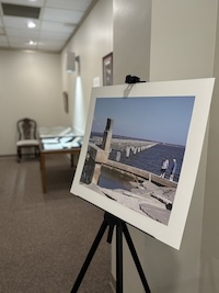 Photograph of a pier destroyed by Hurricane Katrina placed on an easel